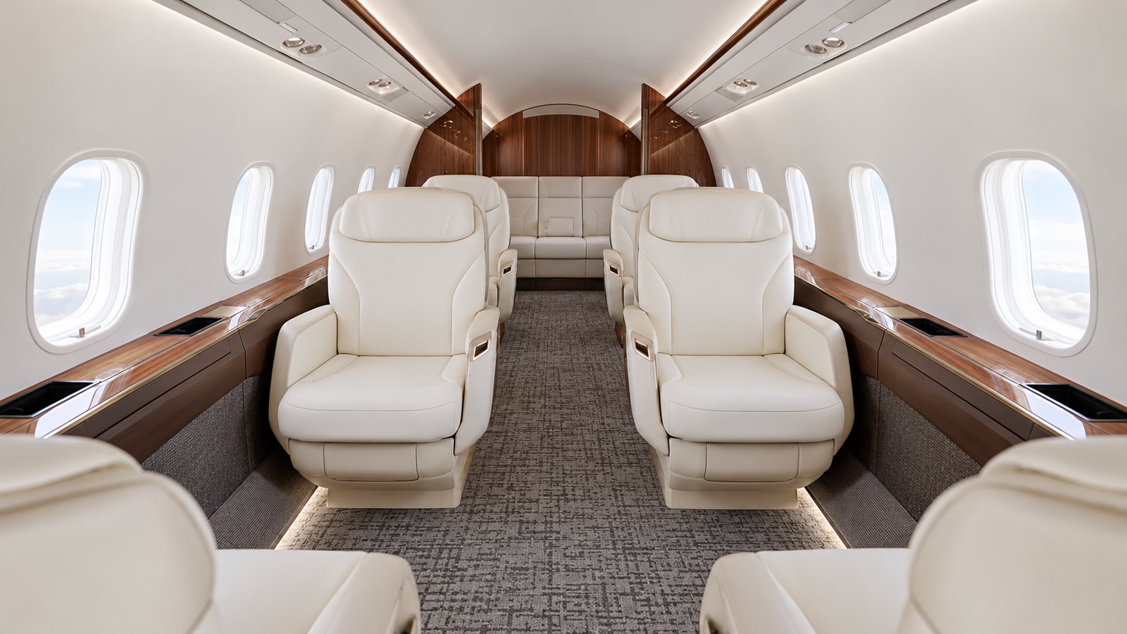 Challenger 3500 cabin looking aft, cream club seats and a divan under a wood veneer bulkhead