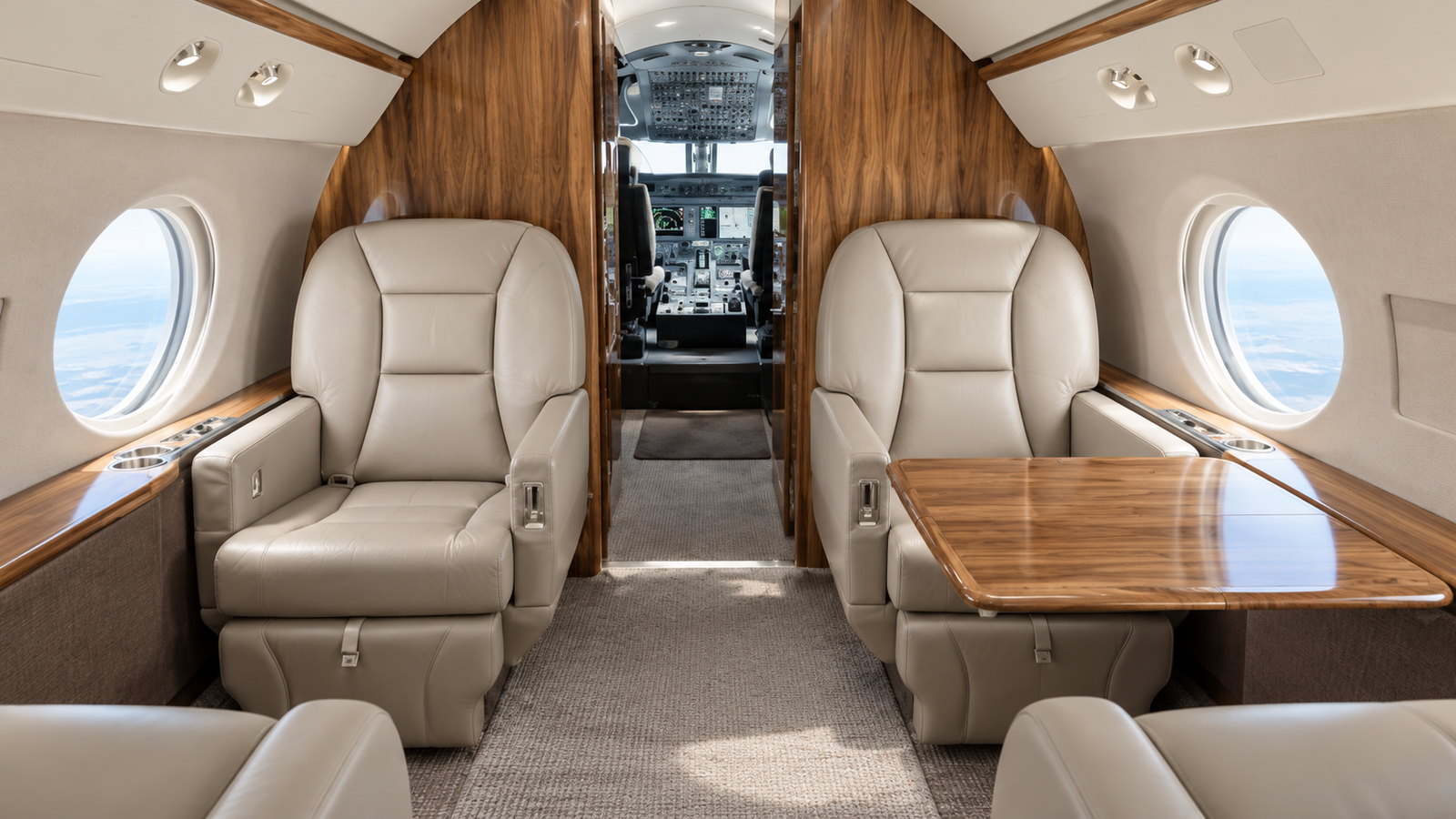 Gulfstream G450 cabin looking forward, club seats and a table in cream leather