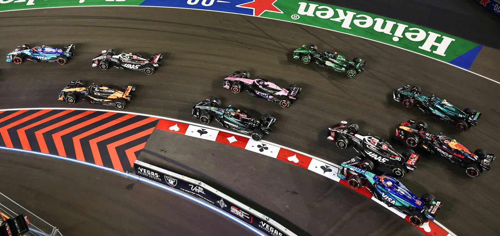 Formula 1 cars through a corner of the Las Vegas Strip circuit at night