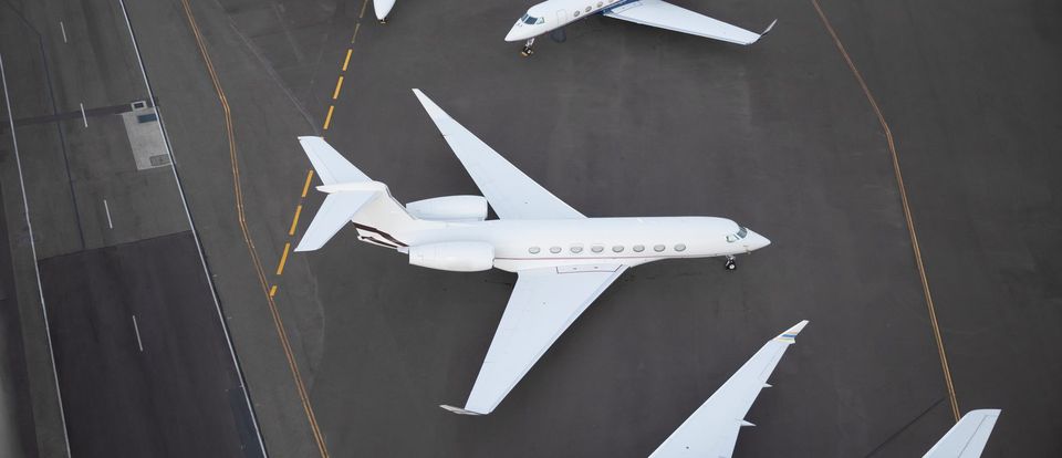 Four business jets parked on an apron, seen from above