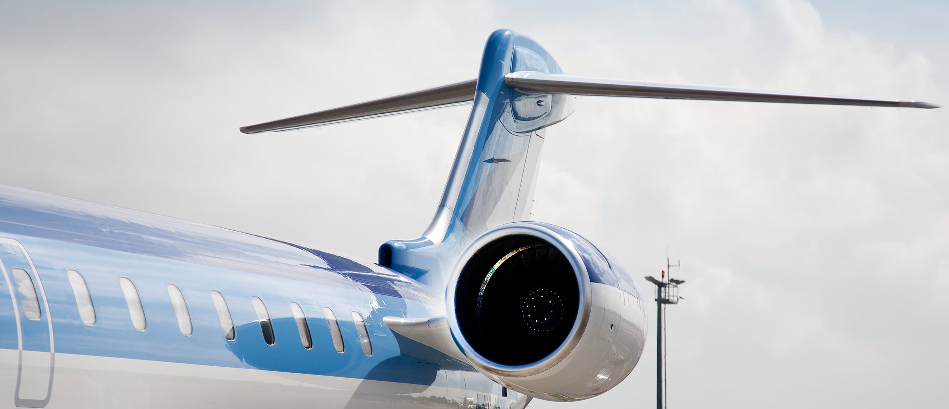 Rear fuselage, tail and engine of a business jet parked on the apron