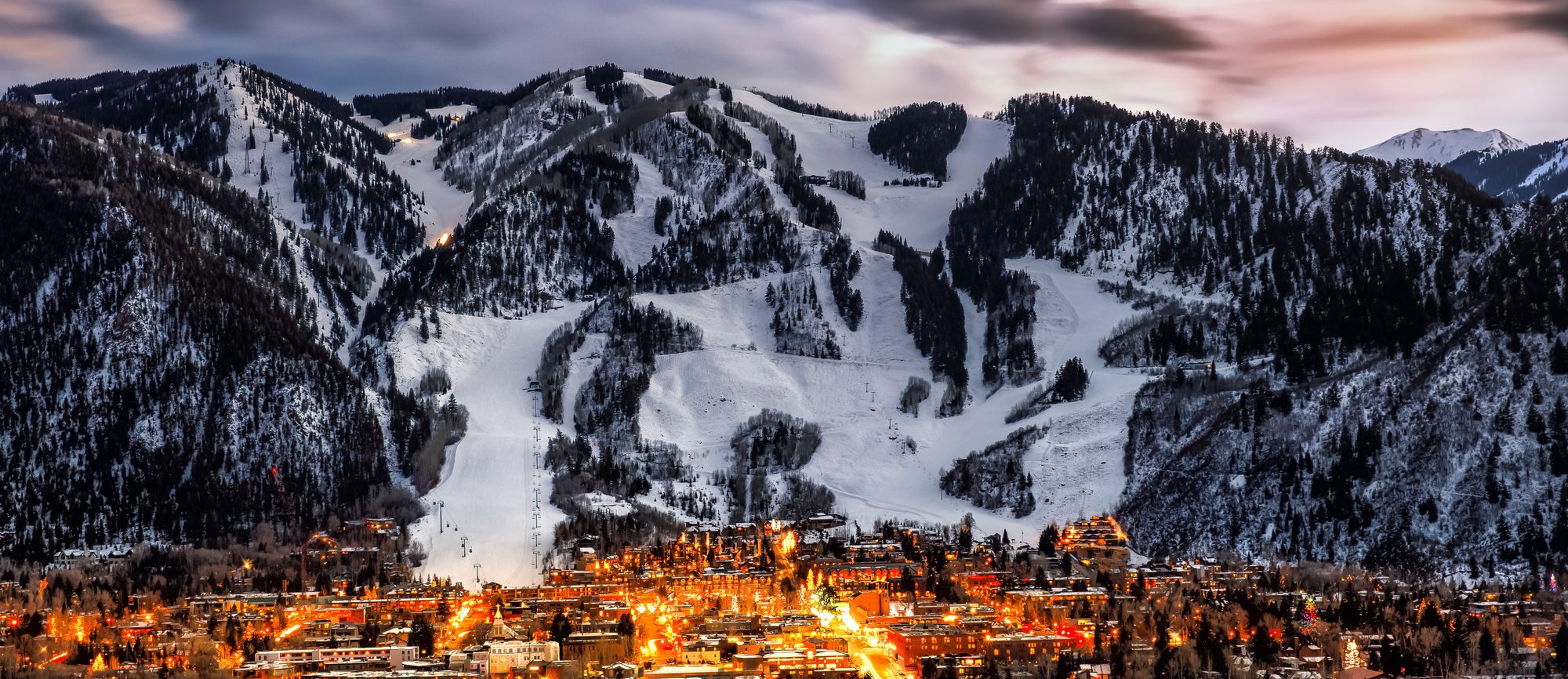 Aspen at dusk with the ski runs lit above the town