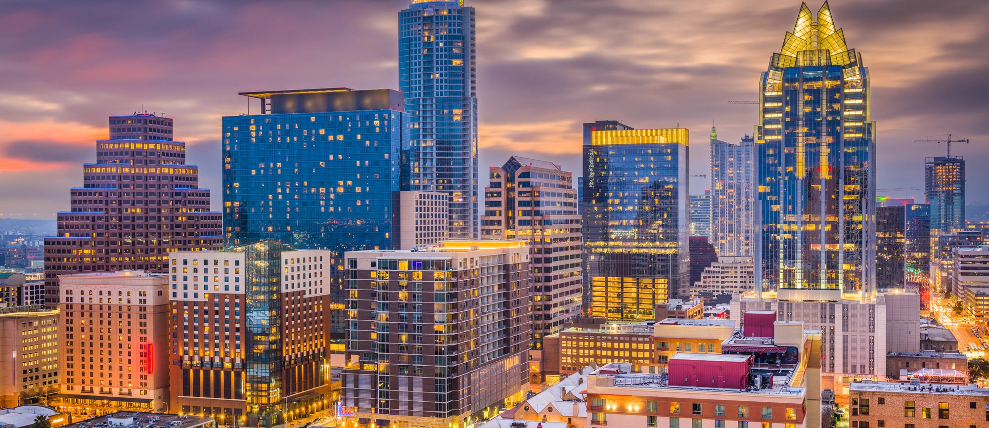 The Austin skyline at dusk, the Frost Bank Tower lit above the city