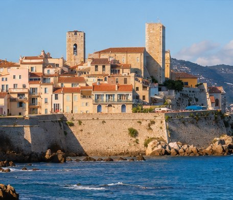 The old town of Cannes above its sea wall, two square towers over the tiled roofs