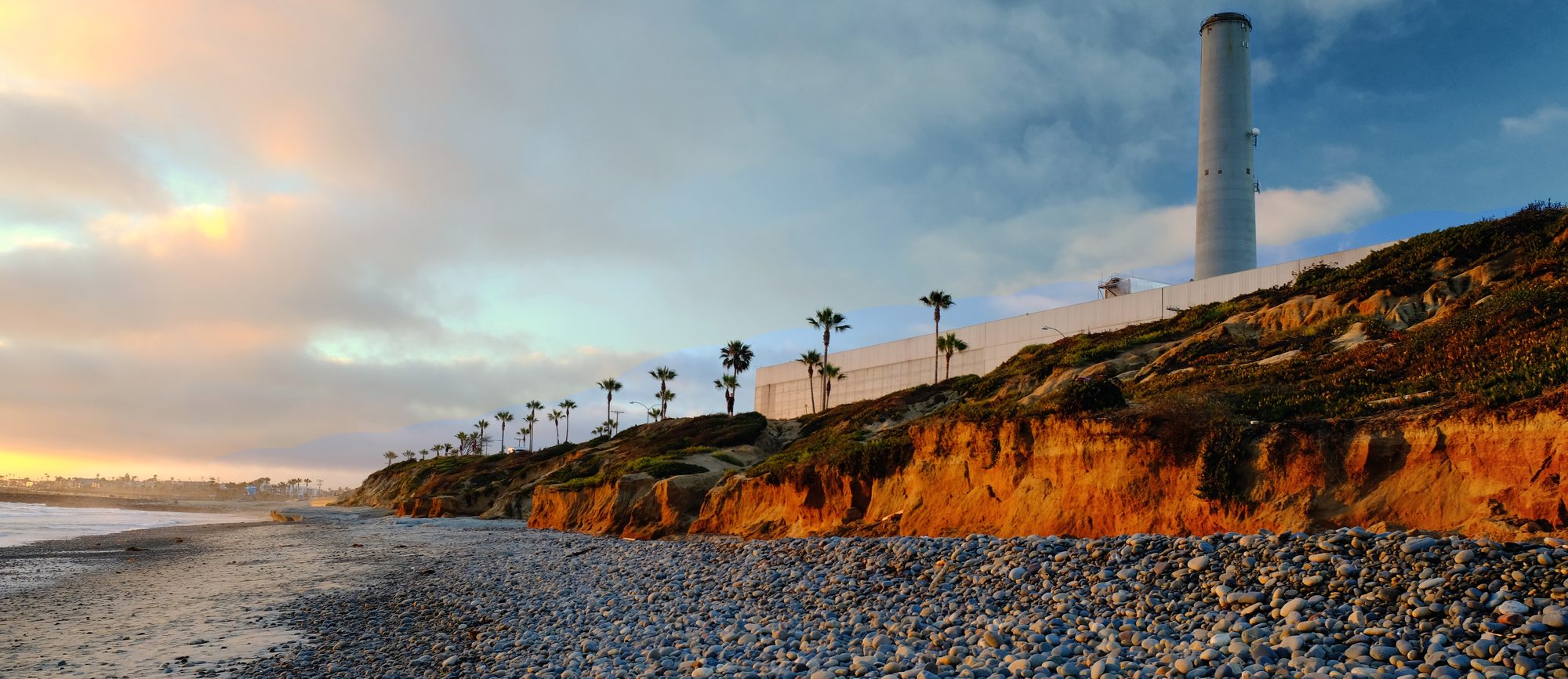Carlsbad State Beach in California at sunset, the bluff and the old power station stack above it