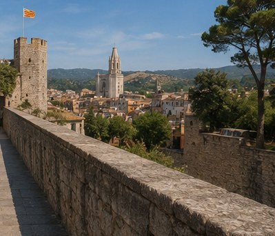 The walkway along the medieval city walls of Girona, a tower and the Catalan flag above the rooftops