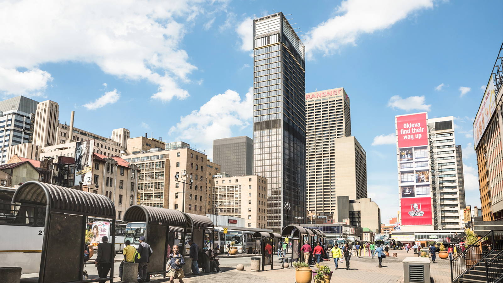 The Johannesburg central business district under a bright sky, with the Carlton Centre rising above the street