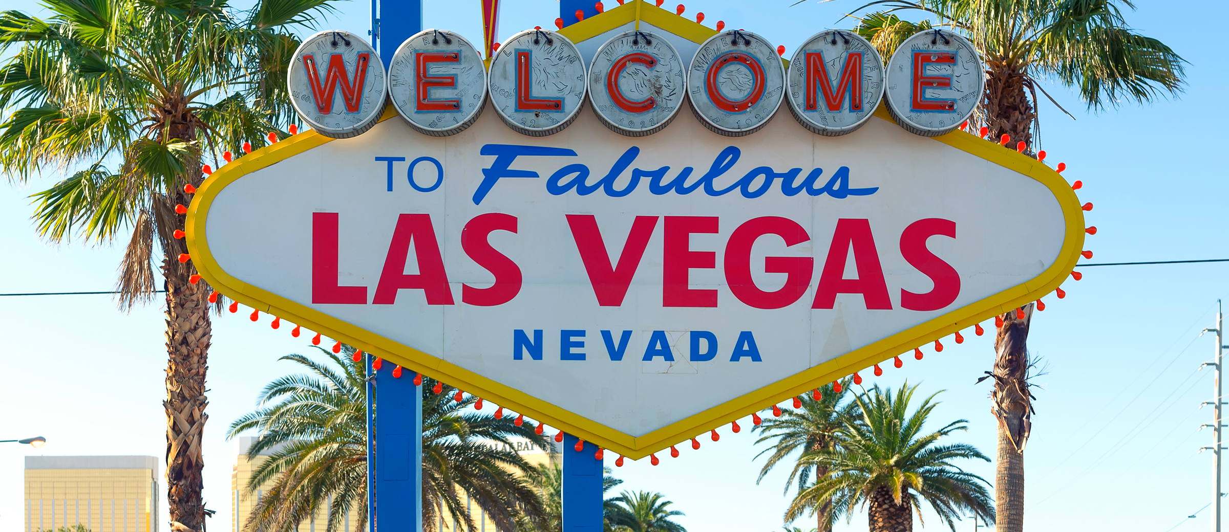 The Welcome to Fabulous Las Vegas sign on the Strip, framed by palm trees