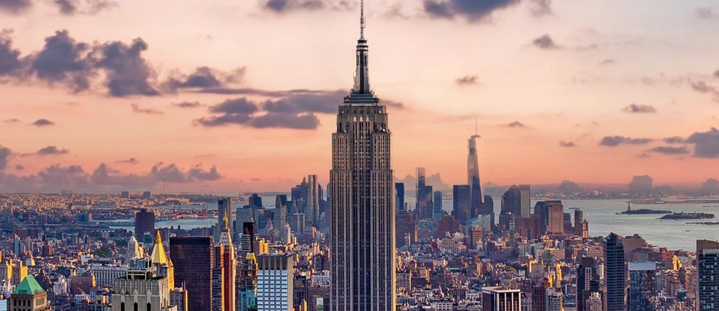 The Midtown Manhattan skyline at sunset, the Empire State Building in the centre and One World Trade Center behind