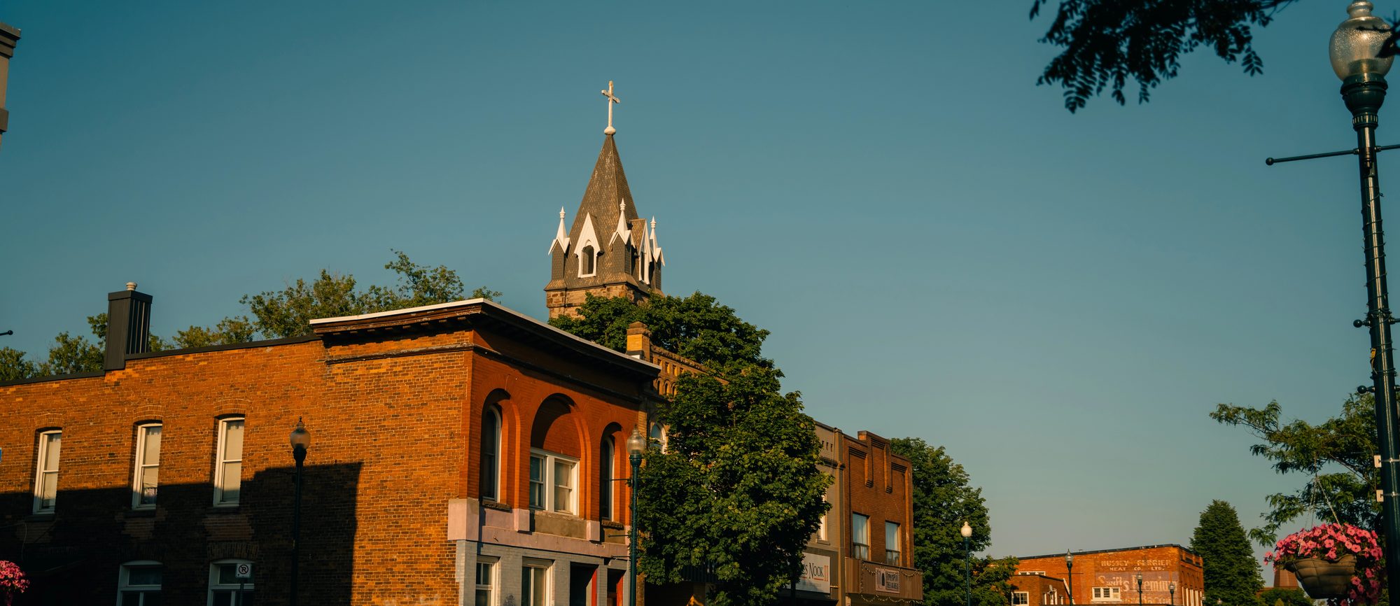 Brick storefronts on Queen Street in Sault Ste Marie, the church spire behind