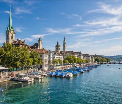 The lake promenade in Zurich, pedal boats moored along the quay and the old town spires behind